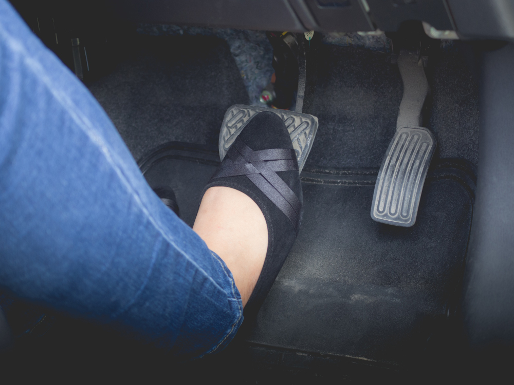 womans foot pressing on brake pedal